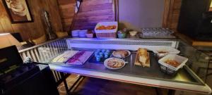 a buffet with food on a glass table at Hotel Valérie in Montgenèvre