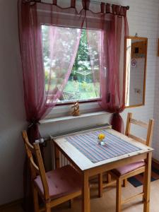 una mesa y dos sillas frente a una ventana en OSTSEEFERIEN IN LICHTENHAGEN-DORF FERIENWOHNUNG, en Elmenhorst Anteil