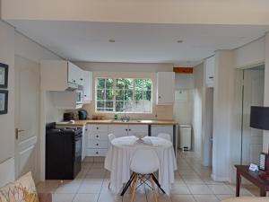 eine Küche mit einem Tisch und weißen Schränken in der Unterkunft Darrenwood Guesthouse & SPA in Johannesburg