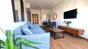 uma sala de estar com um sofá azul e uma mesa em Sea View Apt - 2 min walk to the Beach & 200 Mbit Highspeed internet em Lárnaca
