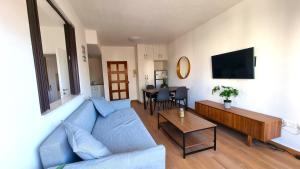 een woonkamer met een blauwe bank en een tafel bij Sea View Apt - 2 min walk to the Beach & 200 Mbit Highspeed internet in Larnaka