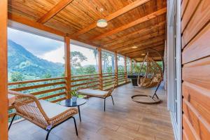 un porche con sillas y una hamaca. en Villa Panorama en La Lomota