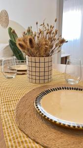 a table with a vase with dried flowers on it at Departamento complejo Vita in Concepción del Uruguay