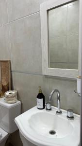 bagno con lavandino, servizi igienici e specchio di Departamento complejo Vita a Concepción del Uruguay