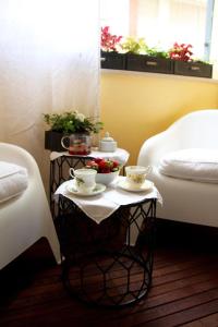 een tafel met twee bedden en twee kopjes en bloembakken bij Nest House & Relax in Civitanova Marche