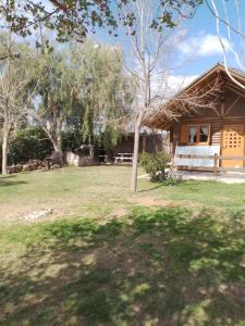 a house with a tree in front of a yard at Cabaña los Aromos in Maipú