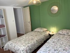- une chambre avec 2 lits et un miroir mural dans l'établissement Maison avec extérieur proche gare des Aubrais, à Orléans