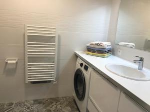 baño blanco con lavadora y lavamanos en Les PECHERS N 2 MAISON DE 87 m2 à 5mn de La Rochelle de l'île de ré et des plages, en La Genilliere