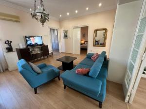 uma sala de estar com dois sofás azuis e uma televisão em Terazije Square Lux Apartment em Belgrado
