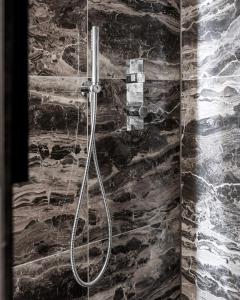 a shower in a bathroom with a stone wall at Le Marin Boutique Hotel in Rotterdam