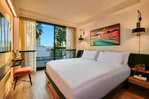 a bedroom with a large bed and a large window at tommie Hollywood, part of Jdv by Hyatt in Los Angeles