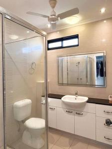 a bathroom with a shower and a toilet and a sink at Bungalow 58 in Lake Bennett