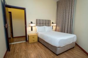 Hagere Apartment Hotel في أديس أبابا: غرفه فندقيه بسرير ونافذه