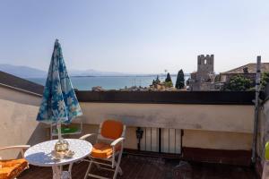 デセンツァーノ・デル・ガルダにあるLa Chicca sui Tetti Centro&Lago By Case al Lagoのバルコニー(テーブル、傘付)
