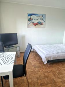 Camera con letto, tavolo e TV di TANI apartament a Łódź