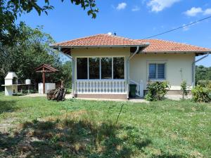 Cette petite maison blanche dispose d'une grande fenêtre. dans l'établissement Apartman Milenkovic, à Malo Laole