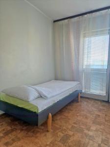 un piccolo letto in una camera con finestra di TANI apartament a Łódź