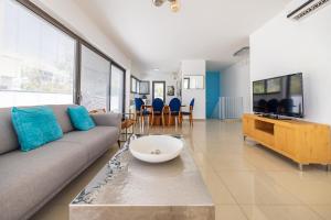 sala de estar con sofá y TV en Ben Yehuda Duplex, en Tel Aviv