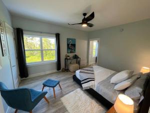 1 dormitorio con 1 cama y ventilador de techo en Bela Vista Getaway - PEI Tourism License #1201185, en Park Corner