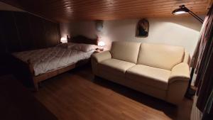 uma sala de estar com um sofá e uma cama em Chalet Rezia em Savognin