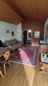 uma sala de estar com um sofá e uma mesa em Chalet Rezia em Savognin