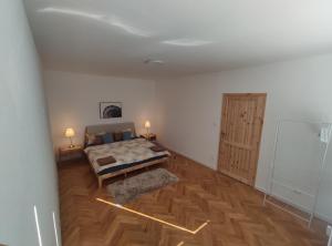 1 dormitorio con 1 cama y suelo de madera en sky apartment, en Prievidza