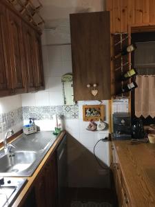 una cocina con armarios de madera y fregadero en Casa Marida en Camigliatello Silano
