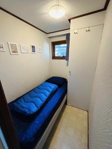 een kleine slaapkamer met een blauw bed erin bij Vakantiepark Klein Vink - 198 in Arcen
