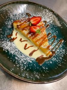 a plate with a piece of cake with strawberries on it at Chambre indépendante Au Relais Normand in Cormeilles
