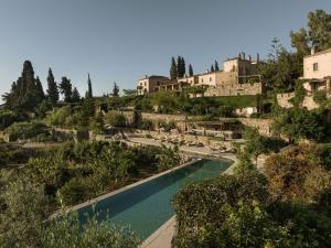 a swimming pool in a garden with buildings in the background at Kinsterna Hotel in Monemvasia