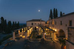 a lit up courtyard of a building at night at Kinsterna Hotel in Monemvasia +62 photos