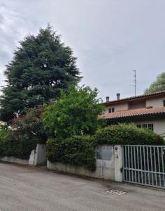 a house with a white fence and a tree at Apartament Cedro del Libano in Marano