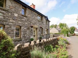 a stone house with a stone fence in front of it at Garreg Wen in Holywell