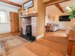 a living room with a brick fireplace in a house at Garreg Wen in Holywell