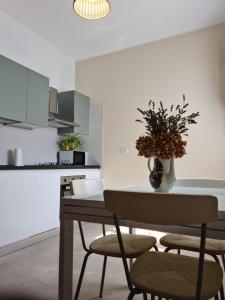 a kitchen with a table with a vase of flowers on it at Apartament Cedro del Libano in Marano