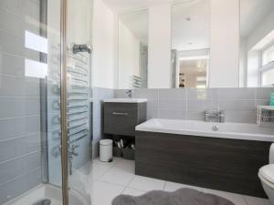a bathroom with a tub and a sink and a shower at Gorgeous House near Windsor & River Thames in Datchet +22 photos