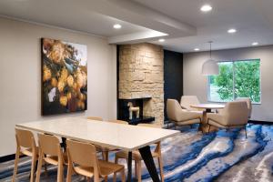 a dining room with a table and chairs and a fireplace at Fairfield Inn & Suites by Marriott Yakima in Yakima