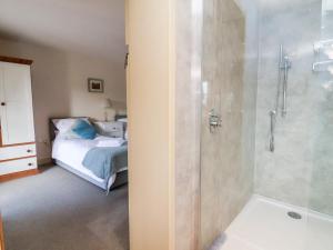 a bathroom with a shower and a bedroom with a bed at Garreg Wen in Holywell +54 photos