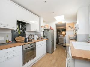 a kitchen with white cabinets and stainless steel appliances at Gorgeous House near Windsor & River Thames in Datchet