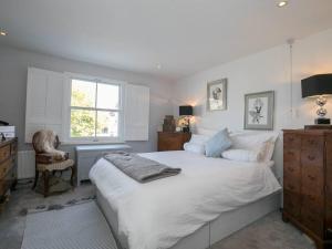 um quarto com uma grande cama branca e uma janela em Gorgeous House near Windsor & River Thames em Datchet