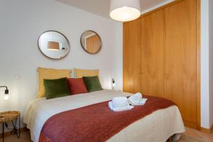 Un dormitorio con una cama grande con toallas. en Arcos d'Alvor, en Alvor 18 fotos más