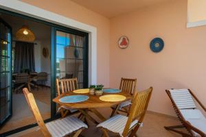 a dining room with a wooden table and chairs at Arcos d'Alvor in Alvor