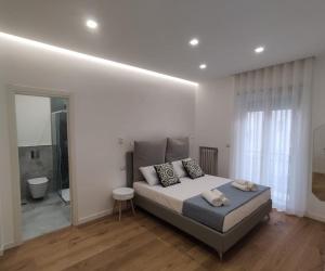 a white bedroom with a bed and a bathroom at Dimora Alba sul Mare in Trani