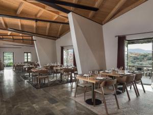 a restaurant with tables and chairs and large windows at Kinsterna Hotel in Monemvasia