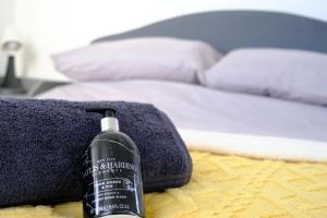 a black bottle of shampoo sitting on a bed next to a bedsenalsenalsenal at Beautiful Cottage with Sea Views Cornwall in Saltash