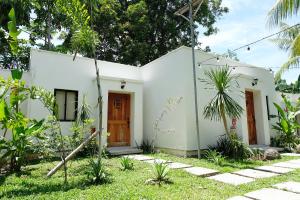 a white house with two doors in a yard at Mad Monkey Dumaguete in Dumaguete
