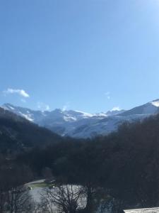 uma vista para um vale com montanhas cobertas de neve em La Villa sur le toit em Lourdes