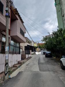 une rue vide à côté d'un bâtiment avec des voitures garées dans l'établissement Hera's Home, à Tirana