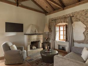 a living room with a couch and a fireplace at Kinsterna Hotel in Monemvasia