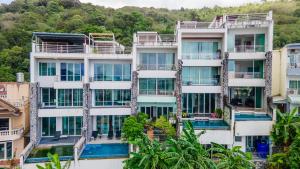 Patong Villa1三卧泳池别墅两个海景房 近班赞江西冷海滩中文管家 في شاطيء باتونغ: مبنى شقق بشرفات واشجار